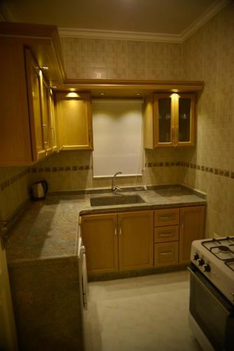 a kitchen with a sink and a stove at Tyre Boutique Apartments in Soûr