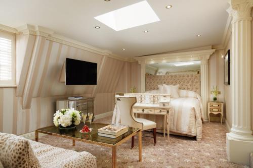 a bedroom with a bed and a desk and a television at Milestone Hotel Kensington in London
