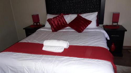 a red and white bed with two towels on it at Tehilah in Sabie