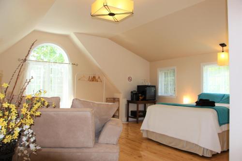 a living room with a bed and a couch at La Maison Jaune D'Eastman in Eastman