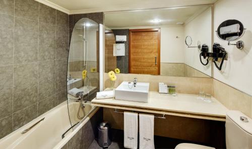 y baño con lavabo y bañera. en Sercotel Gran Hotel Zurbarán en Badajoz