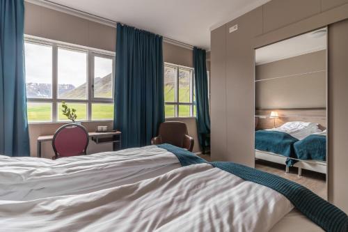 a bedroom with a large bed and a mirror at Holt Inn in Flateyri