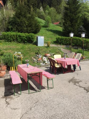 two tables and chairs with red and yellow tables and chairs at Gasthaus Luggwirt in Gnesau