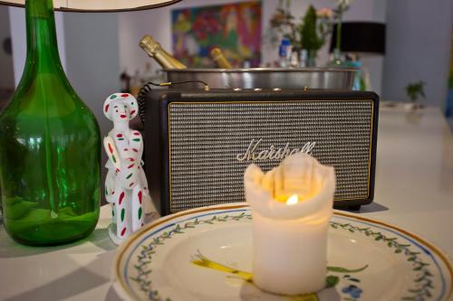 a candle on a plate next to a bottle at Galaxia Boutique Hotel in Can Picafort