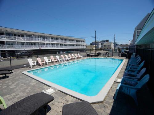 a large swimming pool with chairs and a building at Marguerite Motel in Hampton