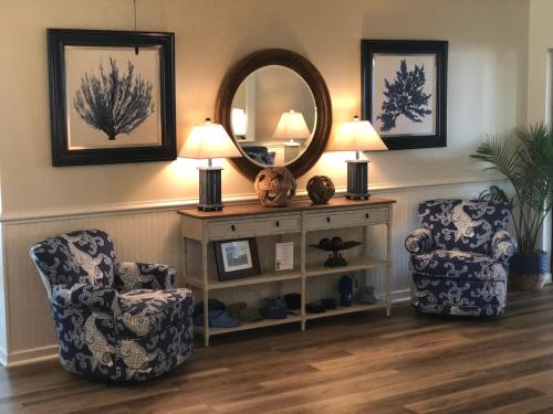 a living room with two chairs and a mirror at Surf Side Hotel in Nags Head