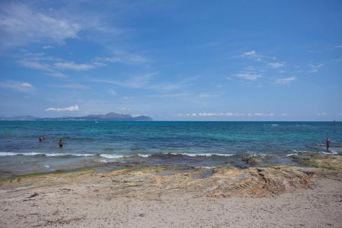 a group of people in the water at the beach at Galaxia Boutique Hotel in Can Picafort