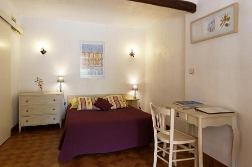 une petite chambre avec un lit et un bureau dans l'établissement Mas le Chêne, à Grimaud