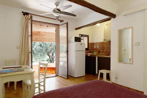 une cuisine avec un réfrigérateur blanc et une table dans l'établissement Mas le Chêne, à Grimaud