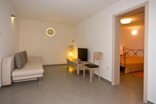 a living room with a couch a chair and a desk at Rooms and Apartments Villa Dama in Pula