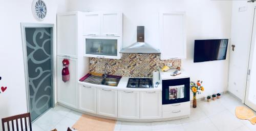 a kitchen with white cabinets and a stove at A Puttata ri Manu in Pozzallo