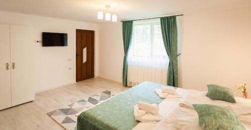 a bedroom with a large bed and a window at Complex Turistic Luminita in Moieciu de Sus