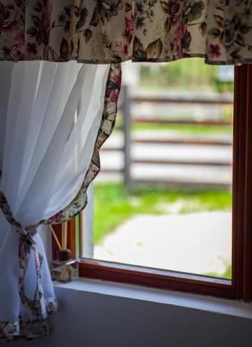 a window with a curtain with a view of a yard at Complex Turistic Luminita in Moieciu de Sus