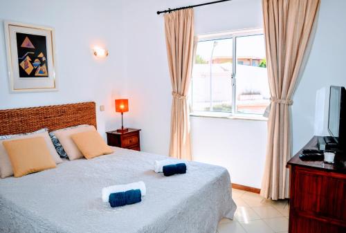 ein Schlafzimmer mit einem Bett mit zwei Kissen darauf in der Unterkunft Albufeira Elegance in Albufeira