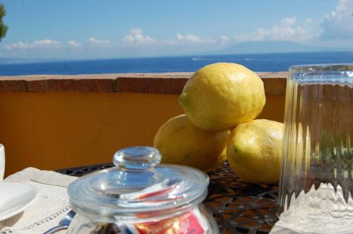 a pile of lemons on a table with a glass jar at La Terrazza sul Mare in Capri