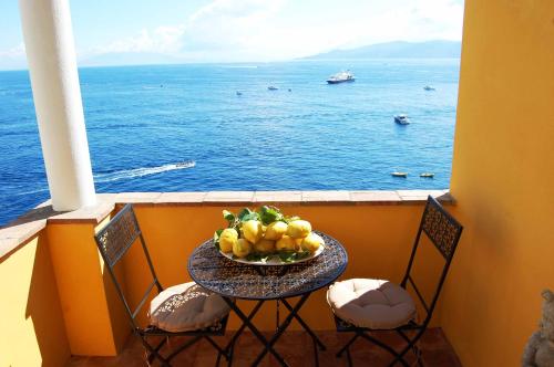a bowl of fruit on a table on a balcony at La Terrazza sul Mare in Capri