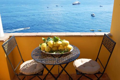 a table with a bowl of fruit and two chairs at La Terrazza sul Mare in Capri