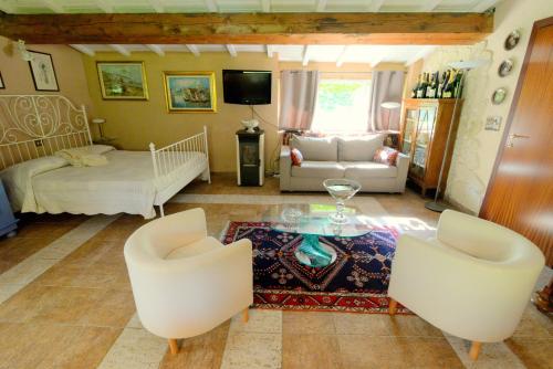 uma sala de estar com uma cama, uma mesa e cadeiras em Podere Casanova em Pistoia