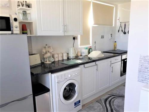 a white kitchen with a washing machine in it at Immaculately Presented Detached Family Chalet - 5 mins to beach, nr Great Yarmouth & Norfolk Broads in Great Yarmouth