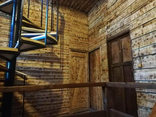 a room with a wooden wall and a door at Hotel Front Castle in Shatili