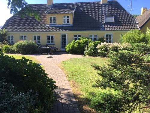 a house with a brick path in front of it at Thurø Rev Guesthouse in Svendborg