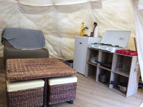 a room with a stove and a chair and a tent at Tipis nature in Gavarnie