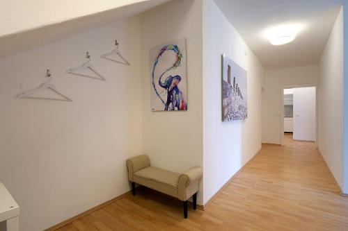 a hallway with a chair and paintings on the wall at Lake View Apartments in Keutschach am See