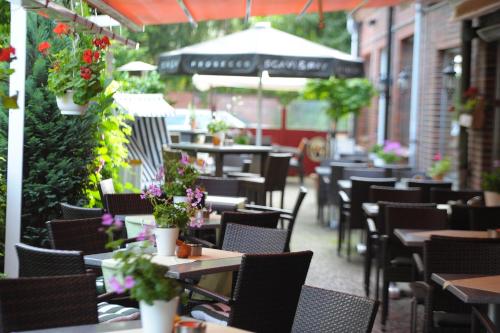 an outdoor restaurant with tables and chairs and flowers at Hotel Zum Zeppelin Hamburg in Hamburg