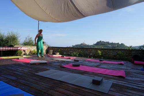 a person standing on a deck with yoga mats at La Quercia Agriturismo in Imperia
