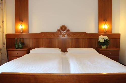 a bedroom with two beds with white sheets at Hotel Lindwurm in Bad Goisern