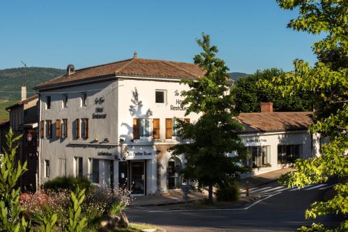 a large white building with trees in the foreground at La Rose in Juliénas
