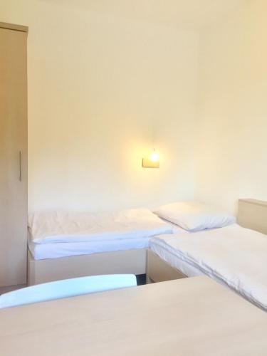 una stanza con tre letti e una luce sul muro di Apartman Diófa a Keszthely