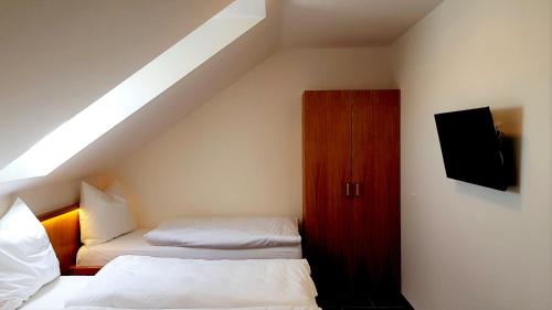 a attic bedroom with two beds and a tv at Penzion U Křížku in Kobylí