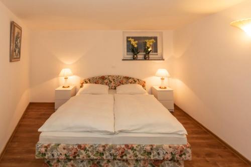 a bedroom with a large bed with two lamps at Apartma Spaans in Radovljica