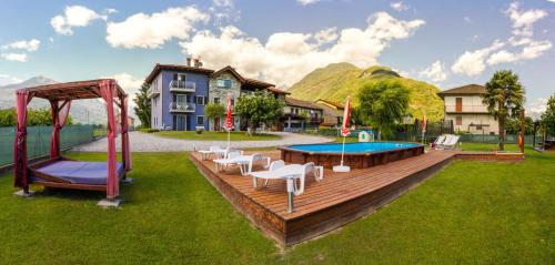 una terraza de madera con piscina y parque infantil en Casa Vacanze Zia Vivina, en Sorico