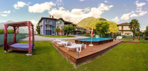 a wooden deck with a pool and a playground at Casa Vacanze Zia Vivina in Sorico