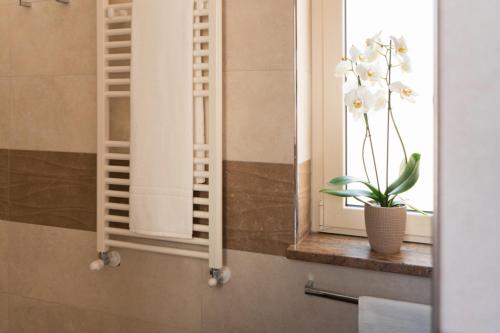 a window with a vase of flowers on a window sill at La Torre del Tempo in Turi
