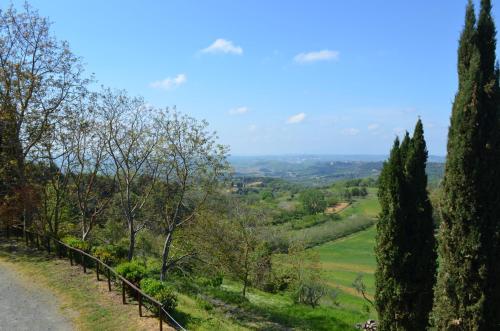 a road in the countryside with trees and a fence at Agriturismo Le Case di San Vivaldo in Montaione