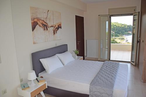 Un dormitorio con una cama grande y un balcón. en Villa Magdalena, en Lixouri