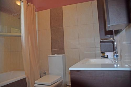 Un baño con inodoro, lavabo y bañera. en Villa Magdalena, en Lixouri