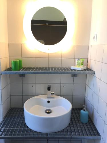 a bathroom with a white sink and a mirror at trash de luxe in Schleswig