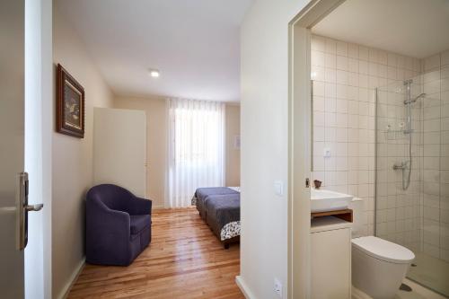 a bathroom with a bed and a shower and a sink at Up Estalagem dos Padres in Albergaria-a-Velha