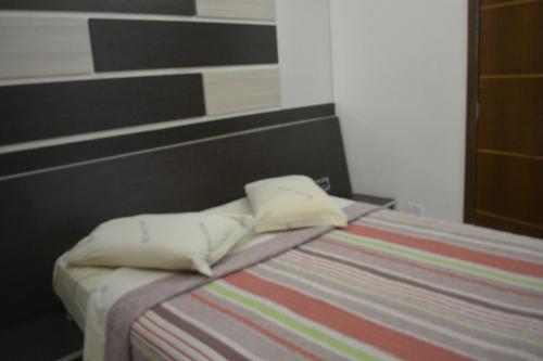 a bed with two pillows on top of it at Hotel Calstar in Sao Paulo