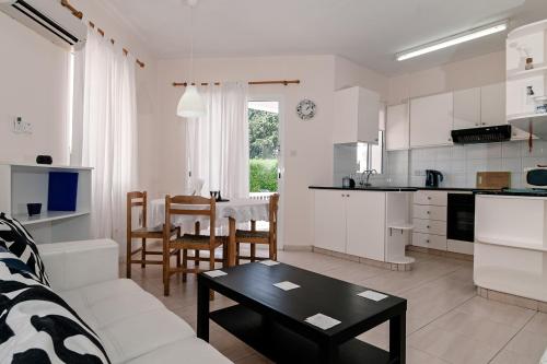 cocina y sala de estar con sofá y mesa en Constantia Gardens Apartments, en Pafos