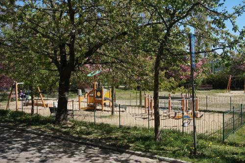 ソポトにあるApartament Sopotの木々と柵のある公園内の遊び場