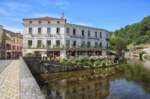 a building next to a river in a town at Hotel Restaurant Charbonnel in Brantôme
