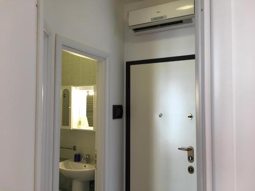 bagno con porta che conduce a un lavandino di Bianco&Nero 61 Apartament a Margherita di Savoia
