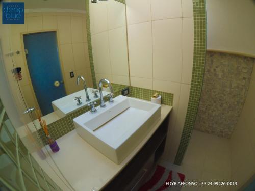 a bathroom with a white sink and a mirror at Residência Angra Deep Blue in Angra dos Reis