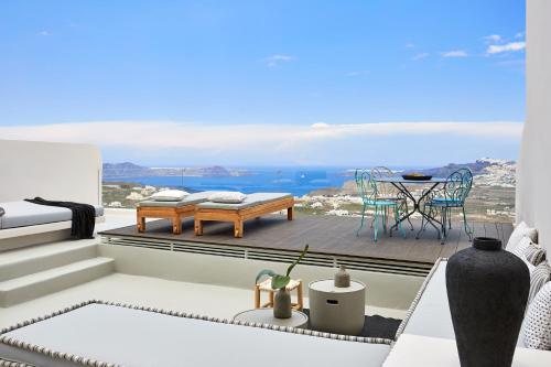 a room with a balcony with a view of the ocean at White & Co. La Torre Suites in Pyrgos