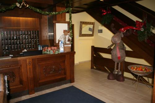 Um homem parado num balcão numa sala com decorações de Natal. em Hotel Lindwurm em Bad Goisern